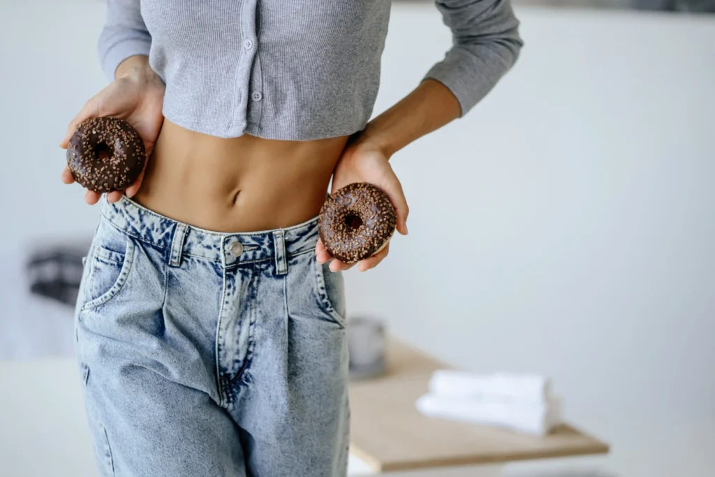 Slim woman holding doughnuts, illustrative image for tirzepatide metabolism research